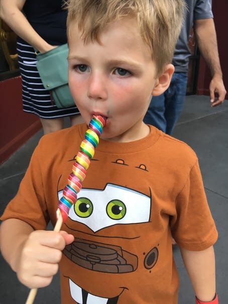 boy eating a Disney World lollipop