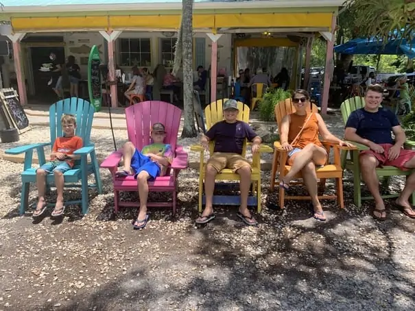 Family sitting in Adirondack chairs at Island Cow restaurant in Sanibel