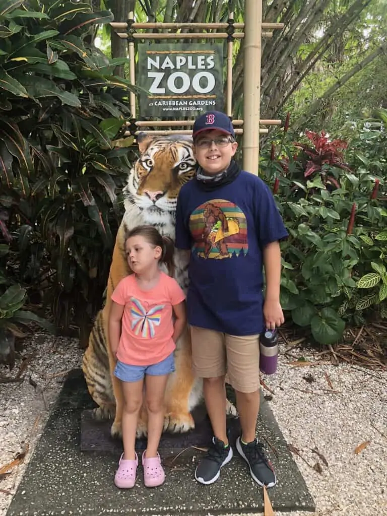 Boy and girl in front of tiger sign at Naples Zoo, one of the things to do in Fort Myers with kids.