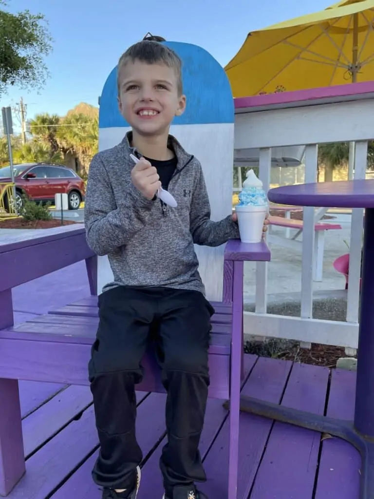 boy eating a snowball at pelicans snowballs in fort myers beach, one of our favorite things to do in Fort Myers with kids.