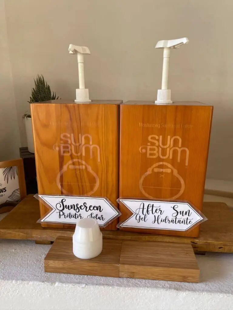 A couple of wood bottles that say Sun Bum. One is Sunscreen and the other is after sun gel.